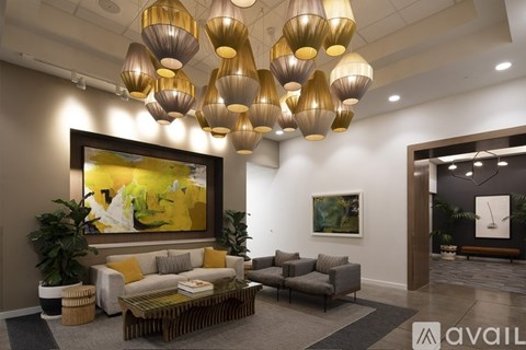 A living room with a large painting on the wall and a coffee table in the center.