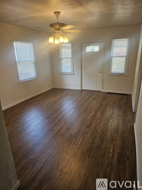 A room with wooden floors and a ceiling fan.