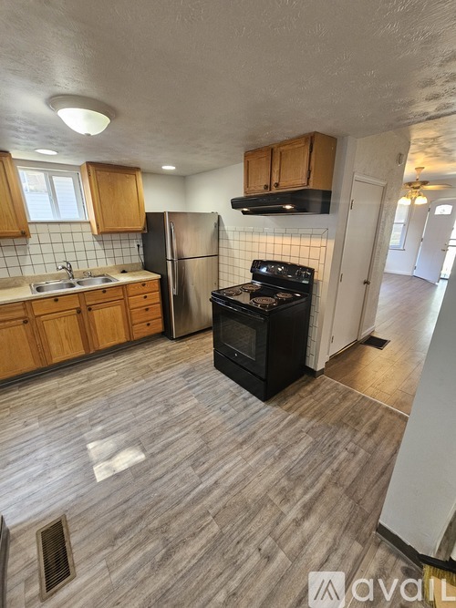 A kitchen with wooden cabinets and a black stove top oven.