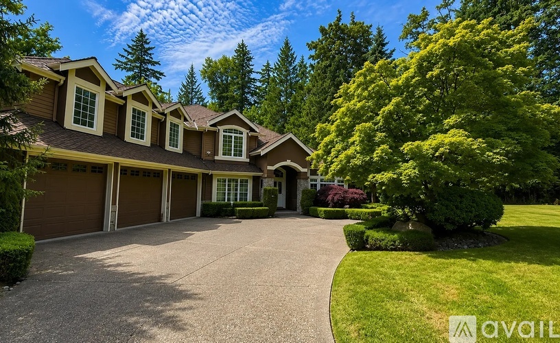 A house with a driveway and trees in the background.