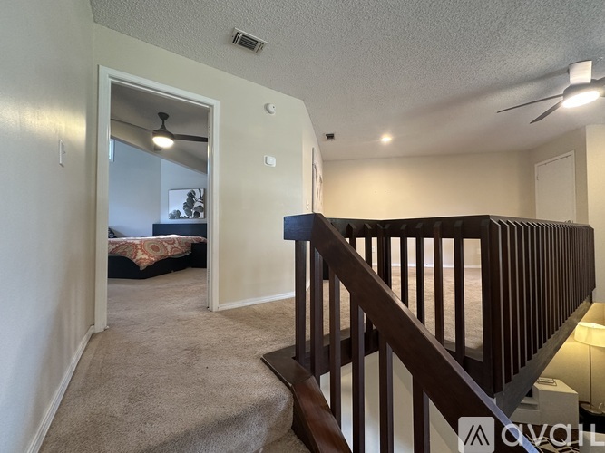 A bedroom with a bed and a mirror is visible from the hallway.