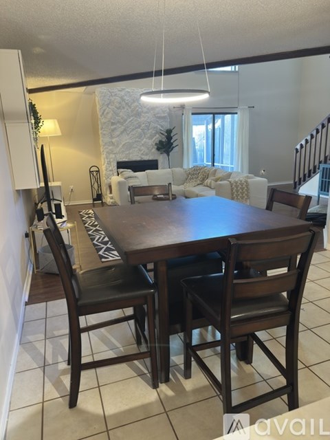 A dining room with a table and chairs.