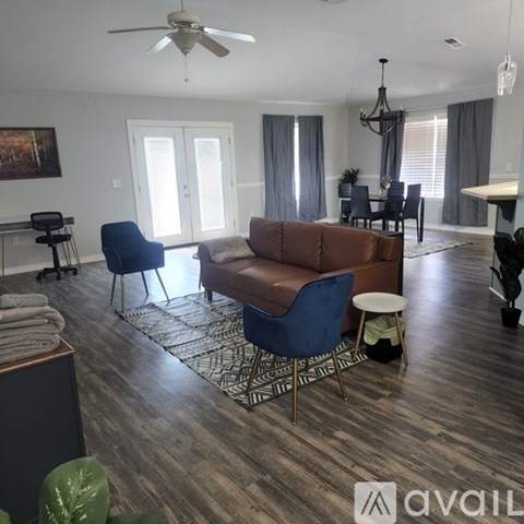 A living room with a brown couch and a blue chair.
