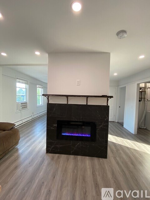 A modern living room with a fireplace and wooden flooring.