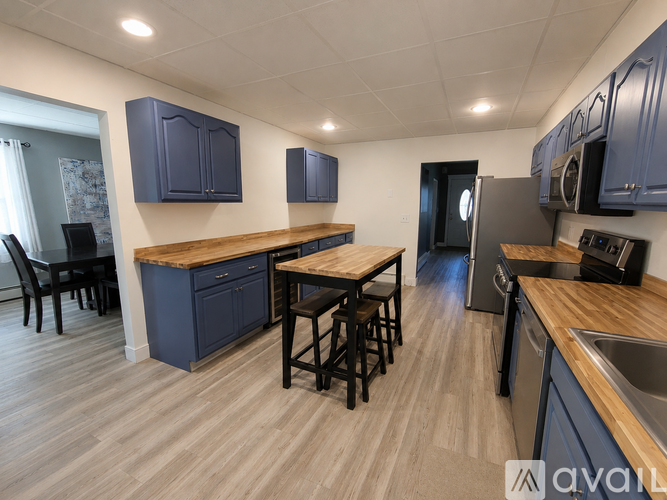 A kitchen with blue cabinets and wooden countertops.