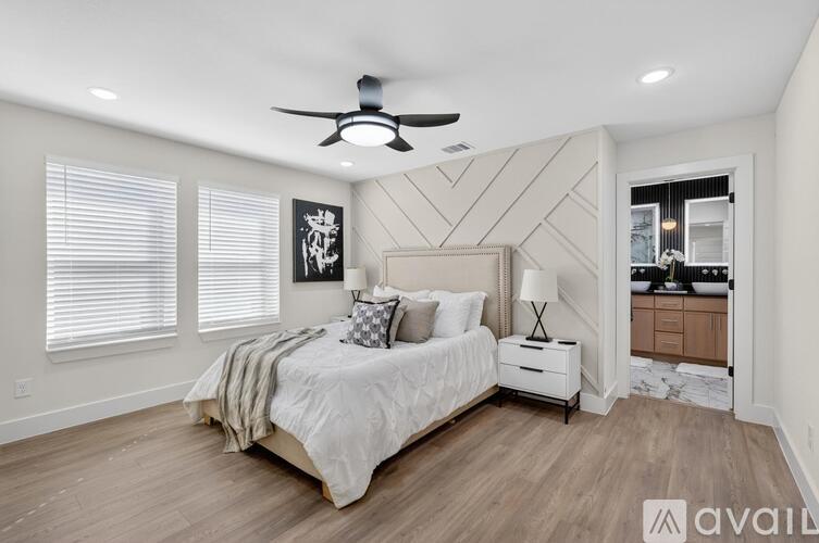 A bedroom with a large bed and a ceiling fan.