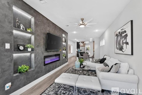 A modern living room with a white couch and a grey wall.