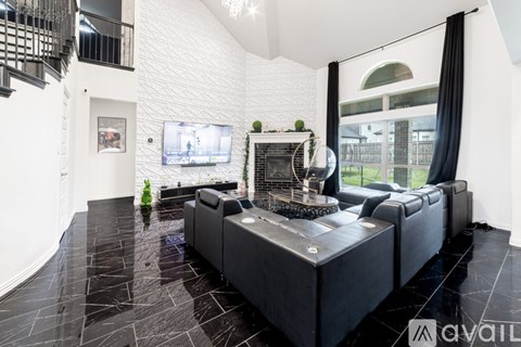 A modern living room with a black leather sofa and a television.