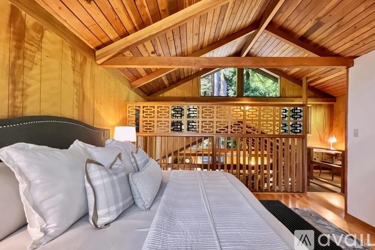 A bedroom with a large bed and wooden ceiling.
