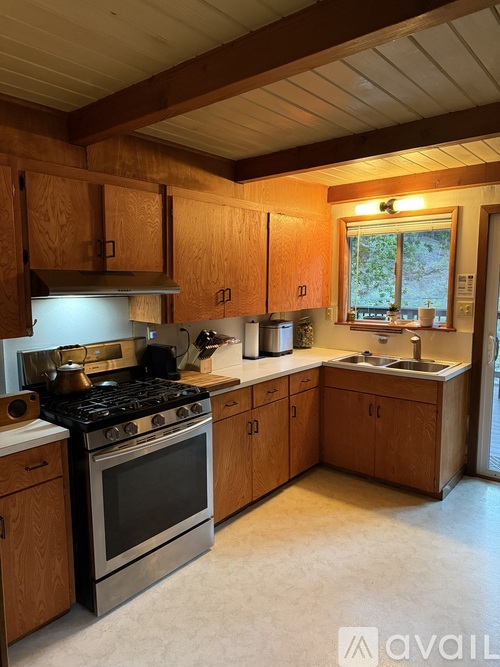 A kitchen with wooden cabinets and a stove top oven.