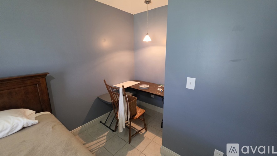 A bedroom with a bed, desk, and chair.