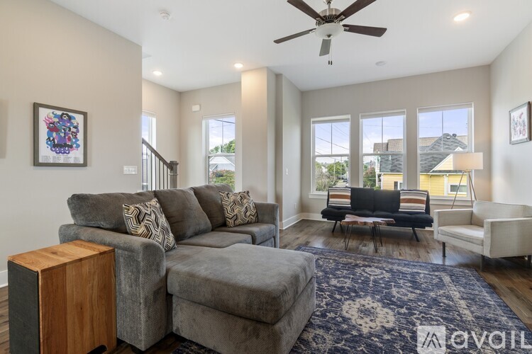 A living room with a grey couch and a wooden speaker.