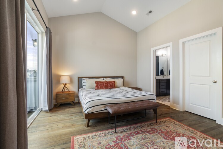 A bedroom with a large bed and a wooden floor.