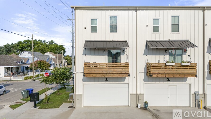 A modern two-story building with a garage on the ground floor and balconies on the upper floor.