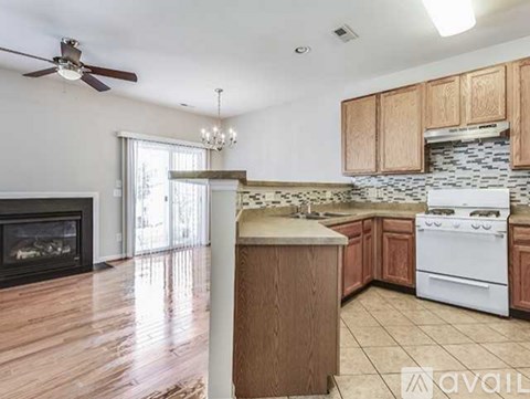 A kitchen with a white stove and wooden cabinets.