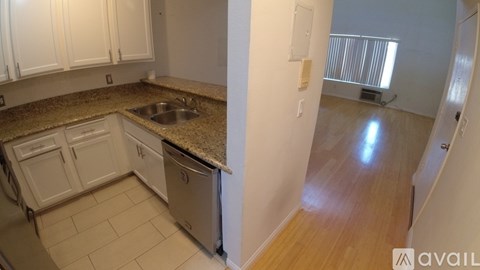 A kitchen with white cabinets and a granite countertop.