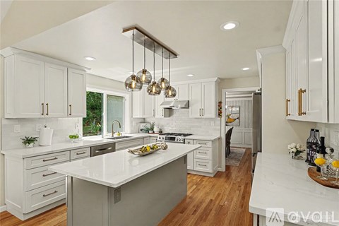A modern kitchen with white cabinets and a central island.