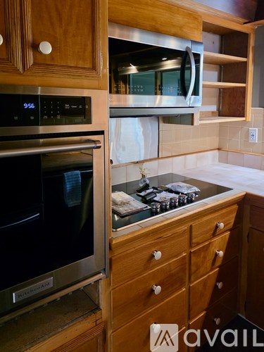 A kitchen with a stove top oven and a microwave above it.