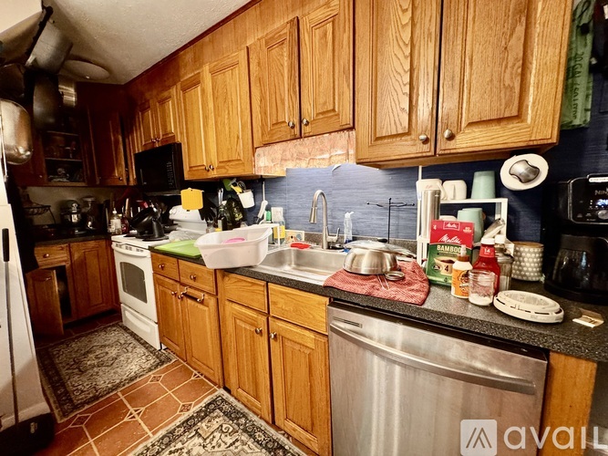 A kitchen with wooden cabinets and a black countertop.