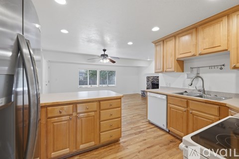 A kitchen with wooden cabinets and a stainless steel refrigerator.