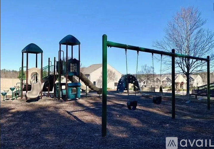 A playground with a green swing set and a blue slide.