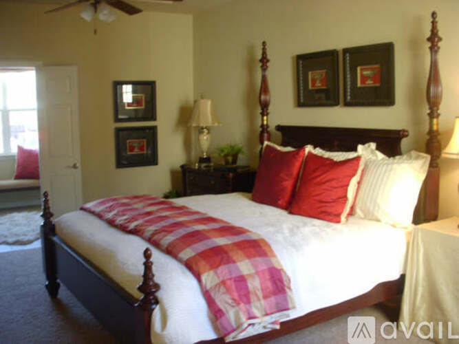 A bedroom with a bed, pillows, and a lamp.