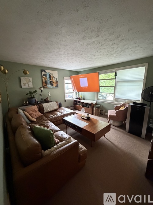 A living room with a brown leather couch and a coffee table.