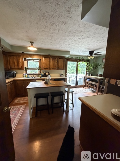 A kitchen with wooden cabinets and a window above the sink.