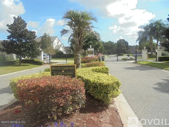 A sign in front of a gated community entrance reads Private Community No Trespassing.