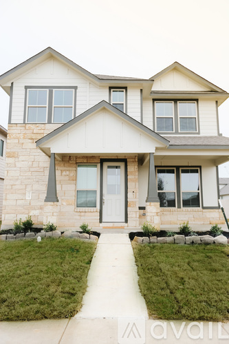 A two-story house with a front yard and a walkway leading to the front door.