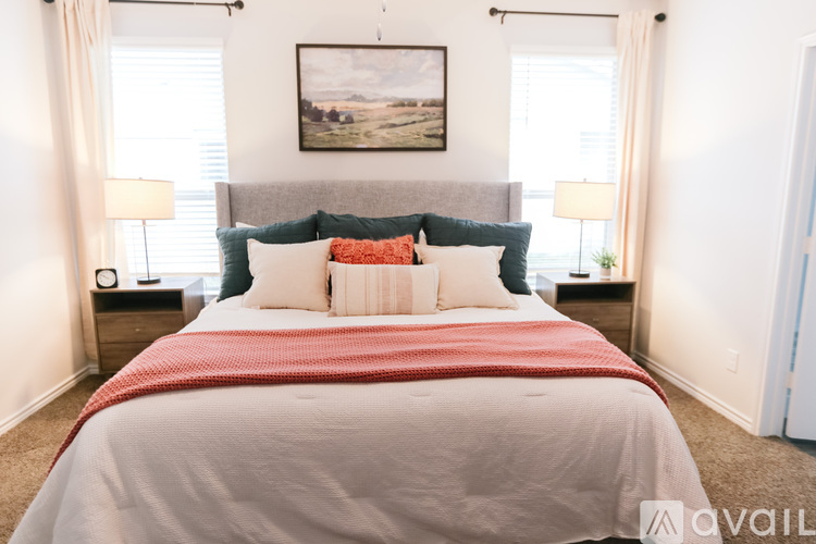 A bedroom with a large bed and a painting on the wall.