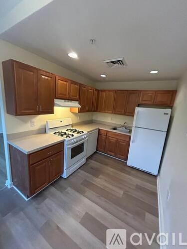 A kitchen with wooden cabinets and a white refrigerator.