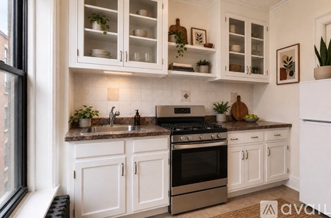 A kitchen with white cabinets and a black stove top oven.