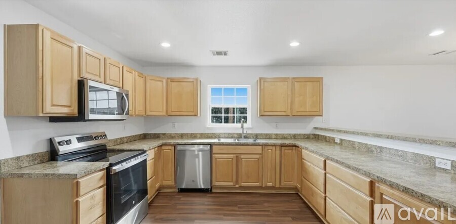 A kitchen with wooden cabinets and a stainless steel dishwasher.