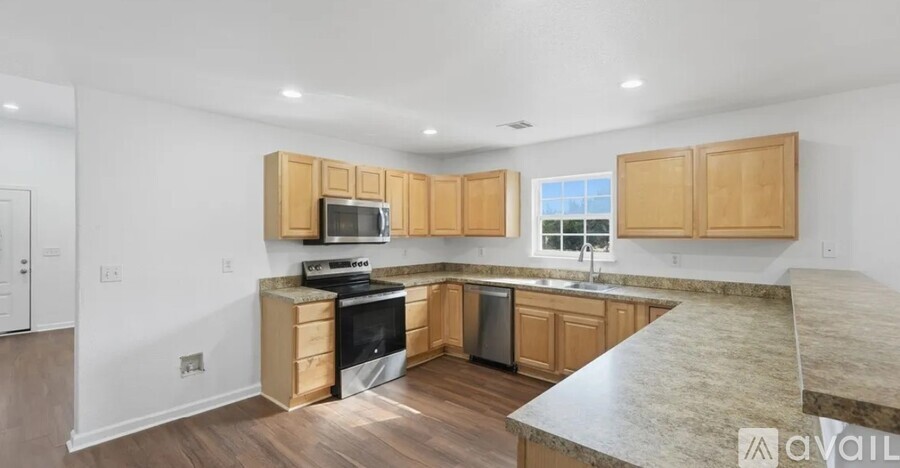 A kitchen with wooden cabinets and a granite countertop.