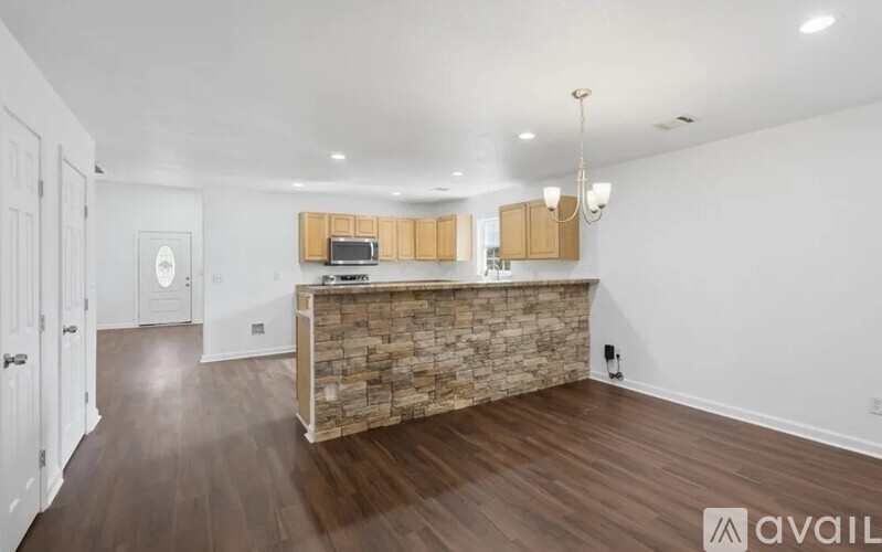 A spacious room with a stone counter and wooden floors.