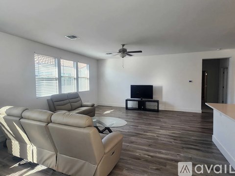 A living room with a large sectional sofa and a flat screen TV.