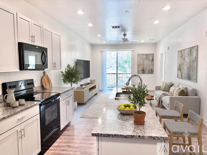 A kitchen with white cabinets and a black microwave above the stove.