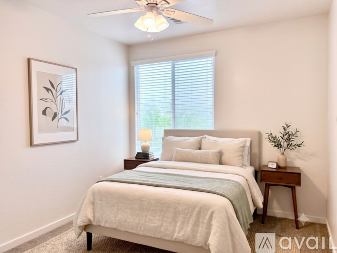 A bedroom with a bed, nightstand, and a framed picture on the wall.