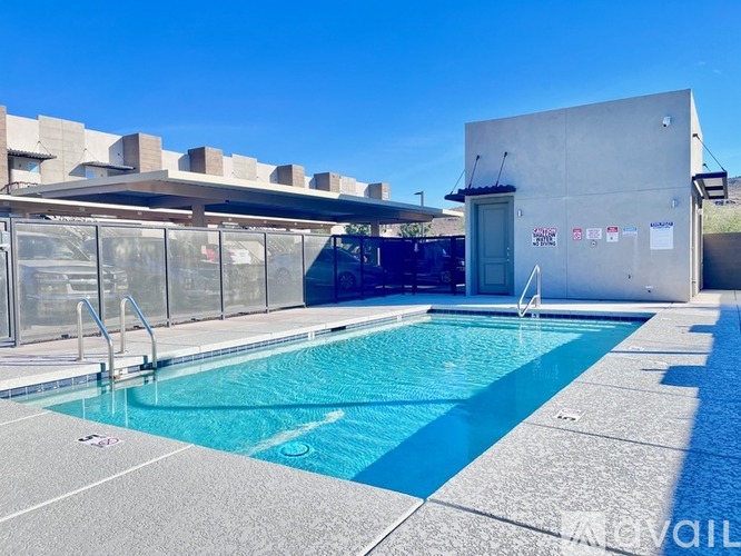 A swimming pool with a blue tinted water and a concrete poolside.