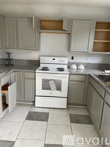 A white stove in a kitchen with a checkered floor.