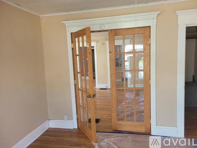 A room with a wooden door and a carpet on the floor.