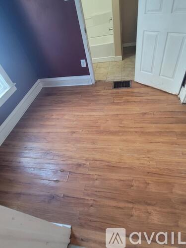 A room with wooden flooring and a white door.