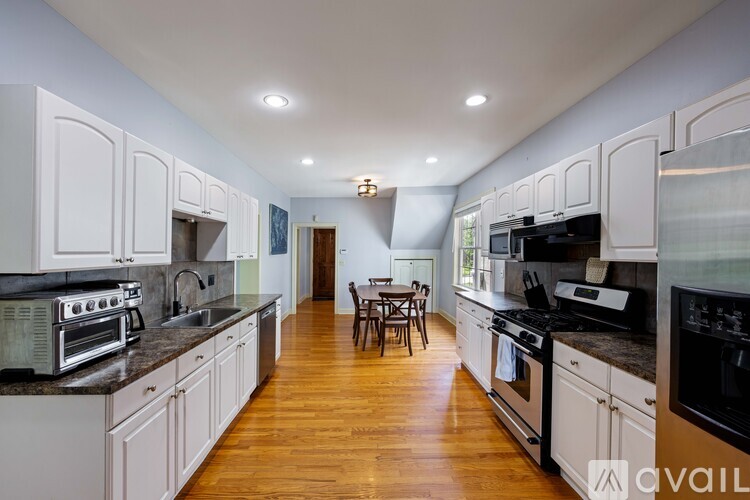 A kitchen with white cabinets and black appliances.