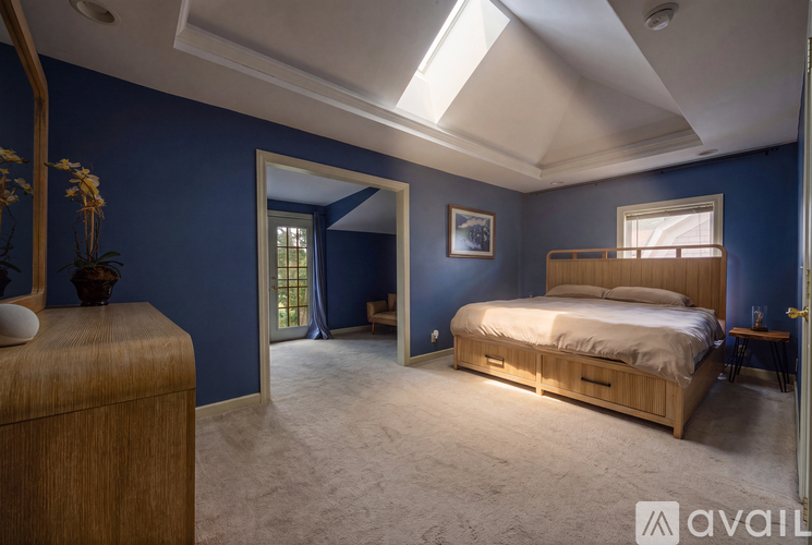 A bedroom with blue walls and a bed with a wooden headboard.