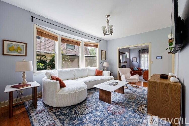 A living room with a white couch and a wooden coffee table.