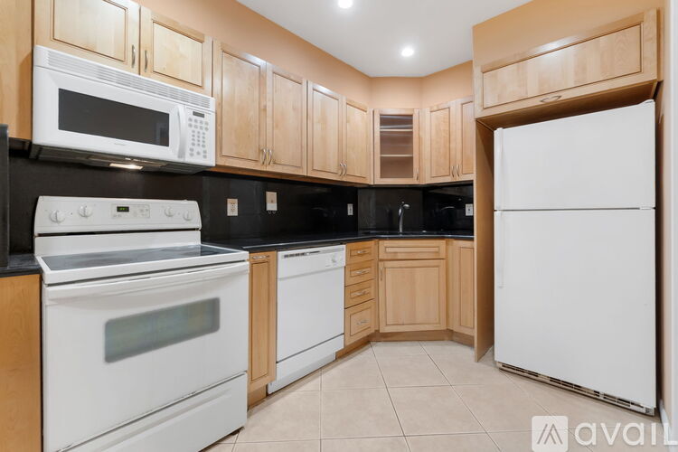 A kitchen with white appliances and wooden cabinets.