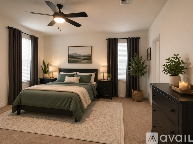 A bedroom with a large bed and a ceiling fan.