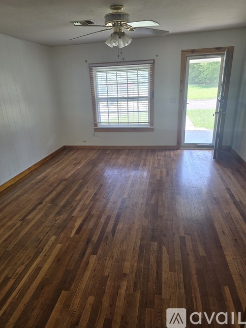 A room with wooden flooring and a ceiling fan.