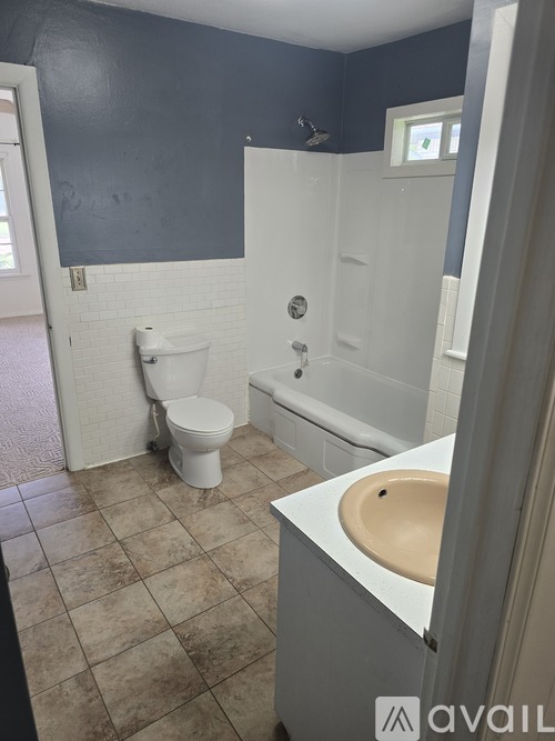 A bathroom with a toilet, sink, and bathtub.